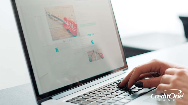 A woman’s hands rest over a laptop’s keyboard while shopping for a guitar online. Perhaps she’s checking if this is a secure website, as a way to protect against identity theft.